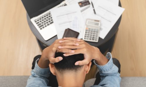 Household financial economic concept, Stressed Young Asian adults are looking at credit card bills issued documents, and apartment loan mortgages and worrying about having no money to pay.